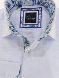 Close-up of a light blue dress shirt with floral trim and Gucci logo.