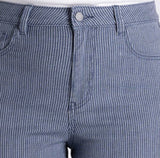 A model wearing a pair of cropped, straight-leg jeans in a dusty slate blue color with subtle vertical pinstripes, paired with a white top and beige platform sandals, against a light gray studio background.