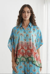 A woman modeling a two-piece matching lounge set with a blue and red abstract pattern, shown in a screenshot of a clothing store page.