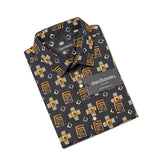 A folded Mechimoto Aztec dress shirt with a black base and a geometric pattern in mustard yellow, white, and gray, shown on a clean white background.