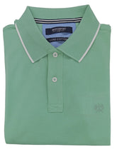 Folded green polo shirt on a light gray background