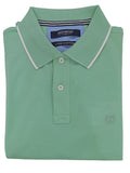 Folded green polo shirt on a light gray background
