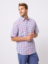 Man wearing a plaid shirt and blue pants on a white background