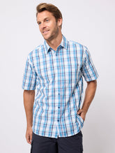 Man wearing a blue and white checkered shirt on a light gray background