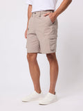 Person wearing beige cargo shorts on a white background