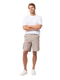 Man wearing a white shirt and beige shorts standing against a white background
