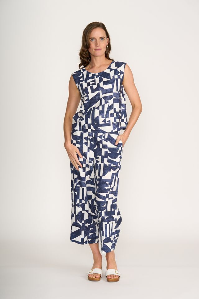 Woman wearing a sleeveless dress with a geometric pattern on a white background