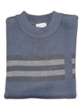 Folded blue sweater with striped pattern on a wooden surface
