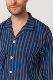 Man wearing a navy and blue striped pajama shirt against a plain background