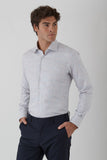 Man wearing a light gray checkered shirt and dark pants on a white background