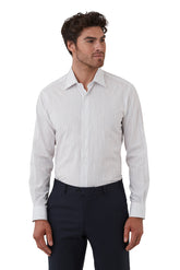 Man wearing a light gray dress shirt with a subtle pattern and dark pants on a white background