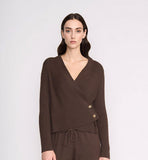Woman wearing a brown outfit with a matching cardigan and pants on a white background
