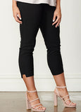 Black cropped capri pants with side slit details, shown on a model wearing light pink high-heeled sandals against a white wall and wood floor.
