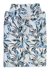 A folded short-sleeve button-up shirt with a blue, gray, and black tropical palm leaf pattern on a white background, displayed on a white surface.