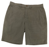 Pair of green shorts on a white surface with a blurred background