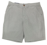 Gray shorts on a white surface with a textured wall background