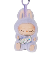 Keychain with a plush toy character in a purple outfit on a white background