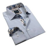 Folded light blue dress shirt with patterned cuffs on a white background