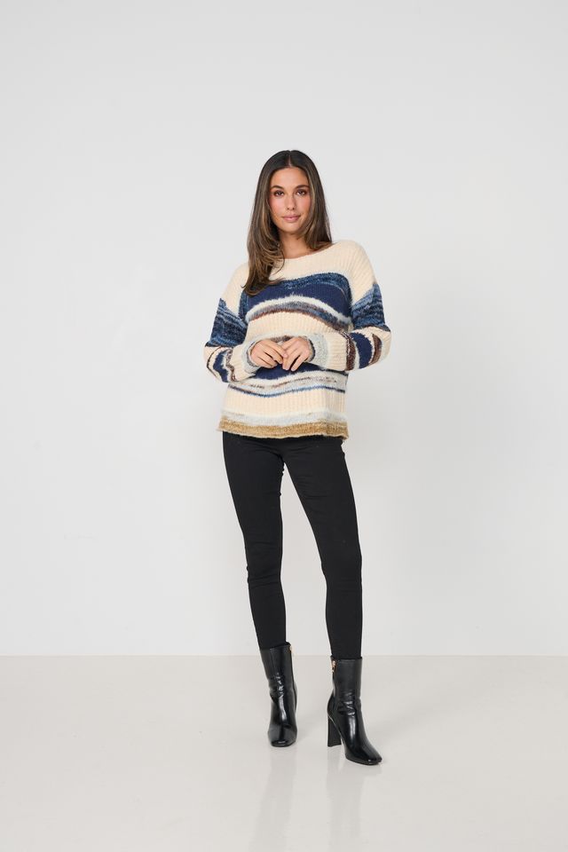 Woman wearing a striped sweater and black leggings on a white background