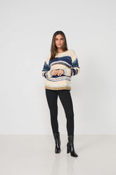 Woman wearing a striped sweater and black leggings on a white background