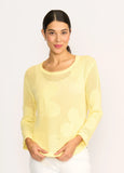 Woman wearing a yellow sweater against a white background