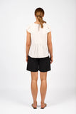 Person wearing a white blouse and black shorts on a white background
