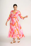 Woman wearing a colorful dress with abstract pattern on a white background