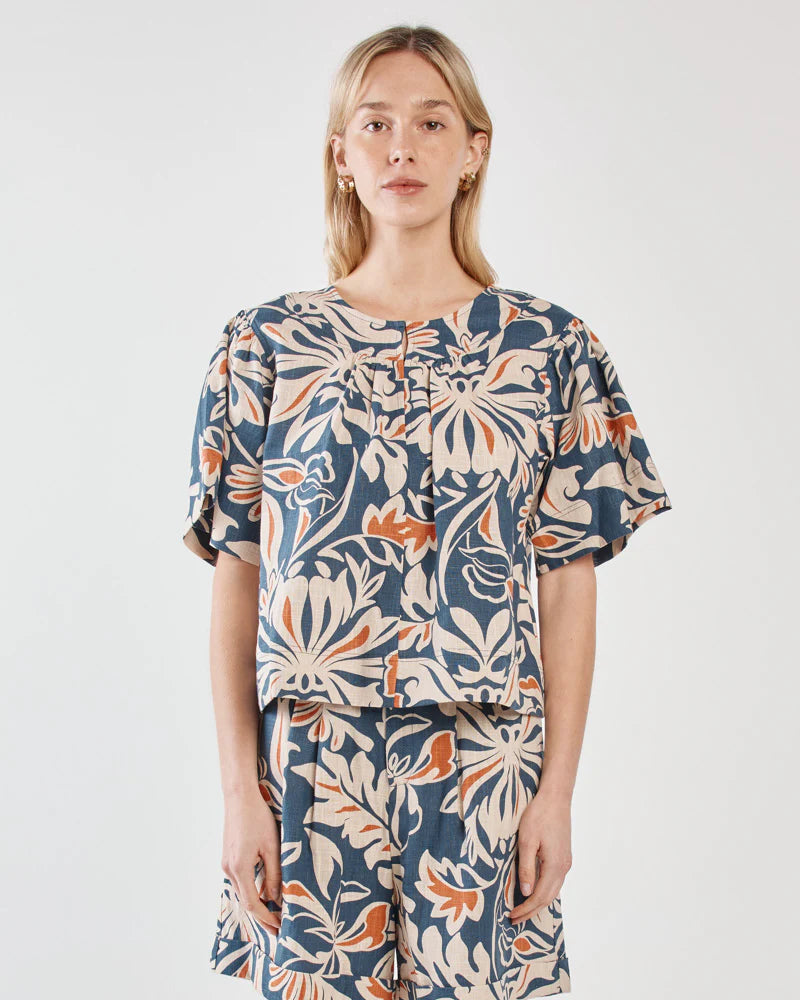 Woman wearing a floral dress with puff sleeves on a white background