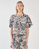 Woman wearing a floral dress with puff sleeves on a white background