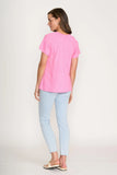 Woman wearing a pink t-shirt and light blue jeans on a white background