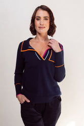Woman wearing a navy blue top with colorful trim on a white background