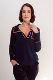Woman wearing a navy blue top with colorful trim on a white background