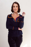 Woman wearing a navy blue outfit with colorful accents on a plain background