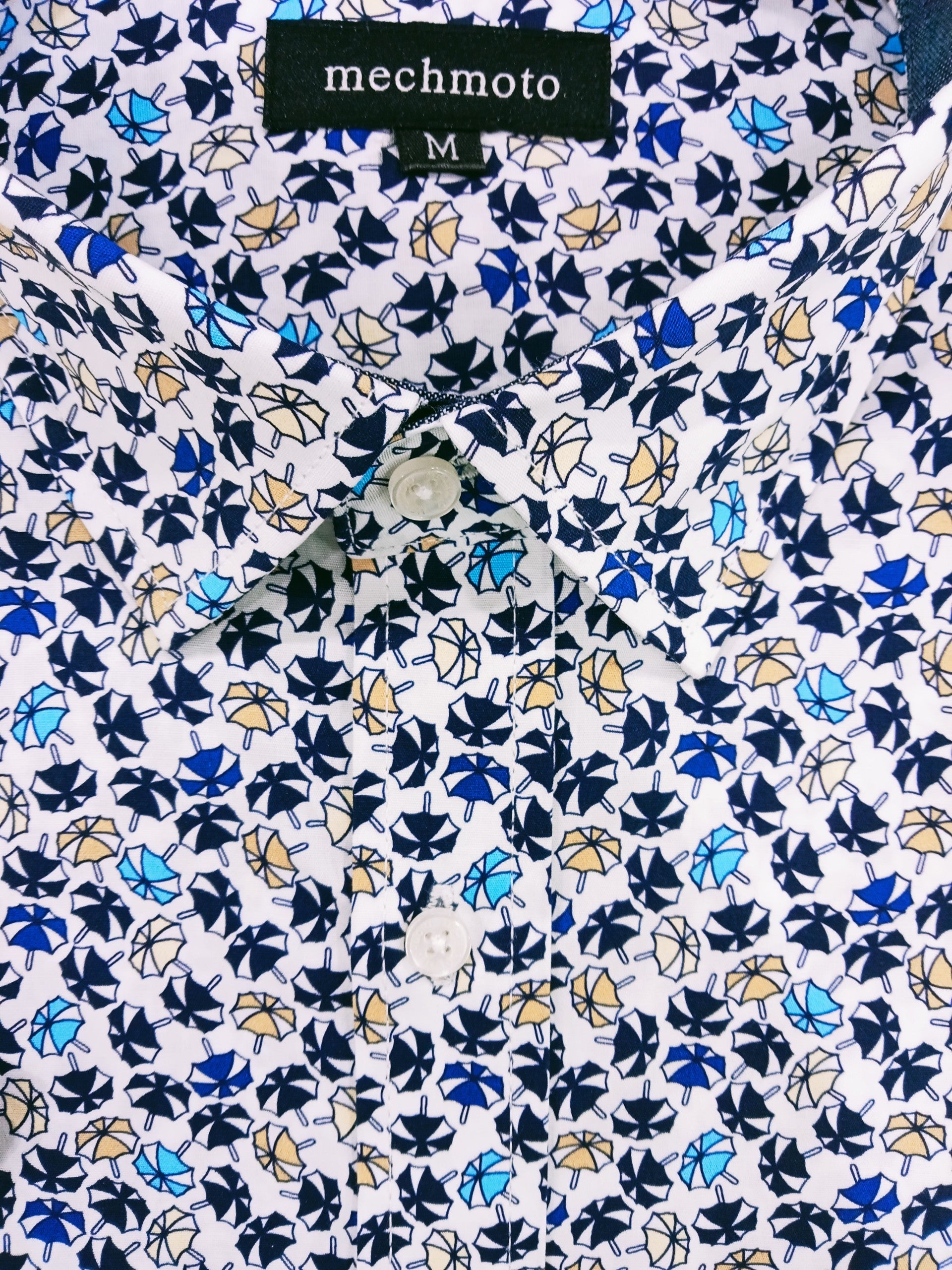 Close-up of a shirt with a floral pattern and 'mechmoto' label.