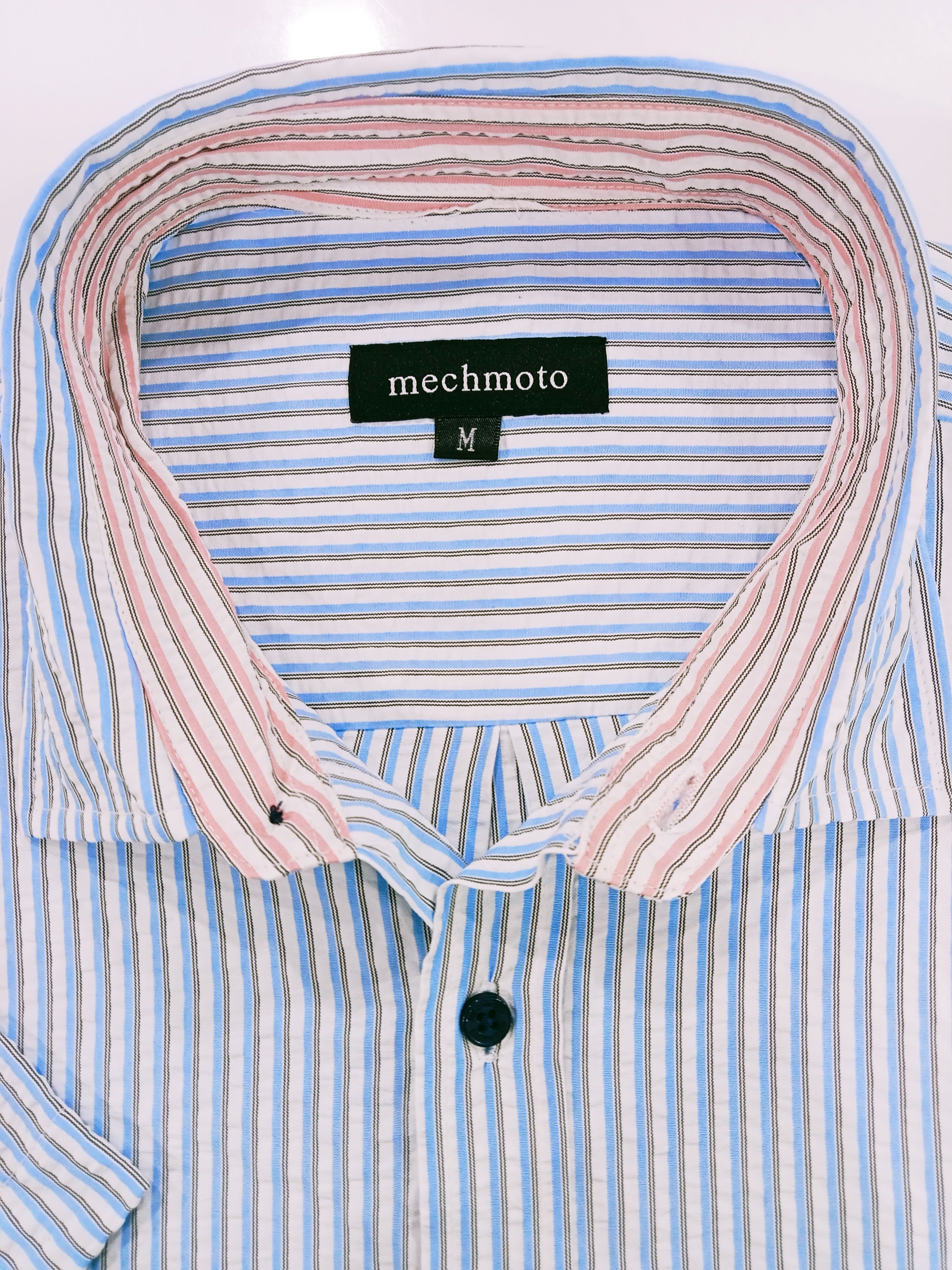 Close-up of a striped shirt with a brand label on a white background