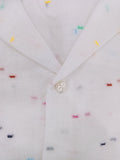 Close-up of a button on a white shirt with small colorful patterns