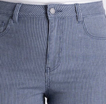 A model wearing a pair of cropped, straight-leg jeans in a dusty slate blue color with subtle vertical pinstripes, paired with a white top and beige platform sandals, against a light gray studio background.