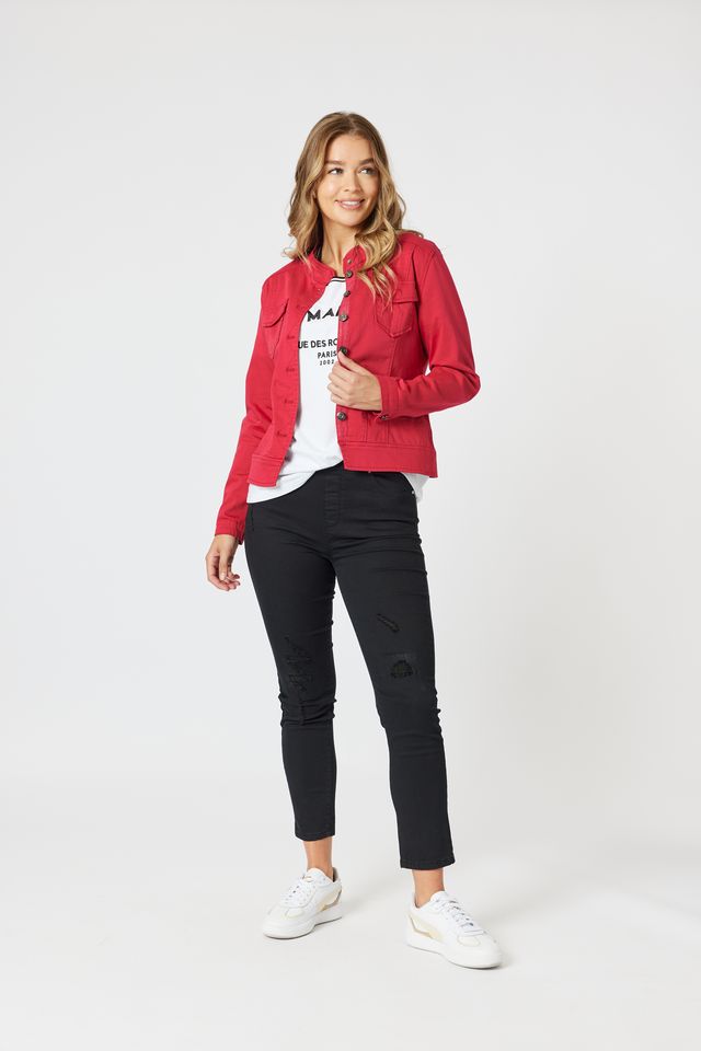 Woman wearing a red jacket, white shirt, black pants, and white sneakers on a white background