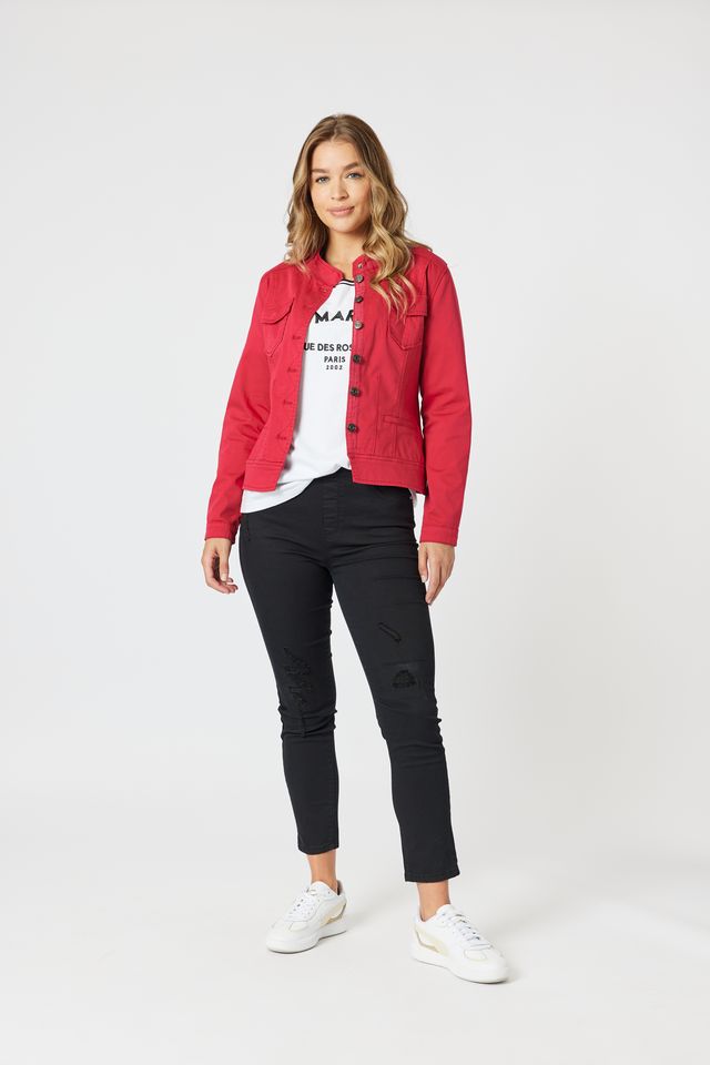 Woman wearing a red jacket, white shirt, black pants, and white sneakers on a white background