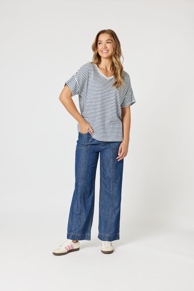 Woman wearing a striped shirt and blue jeans on a white background