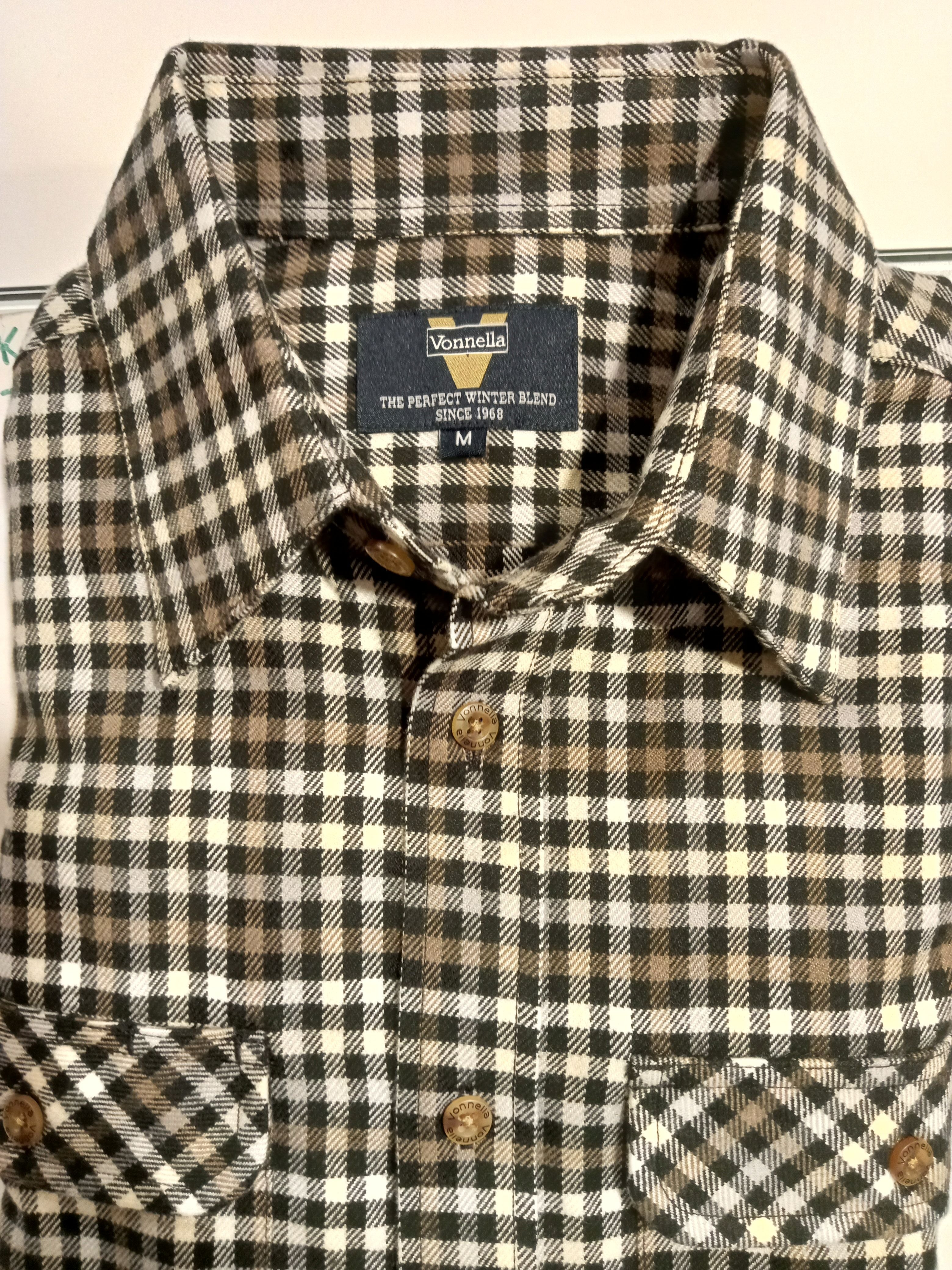 Plaid shirt with a visible label on a plain background