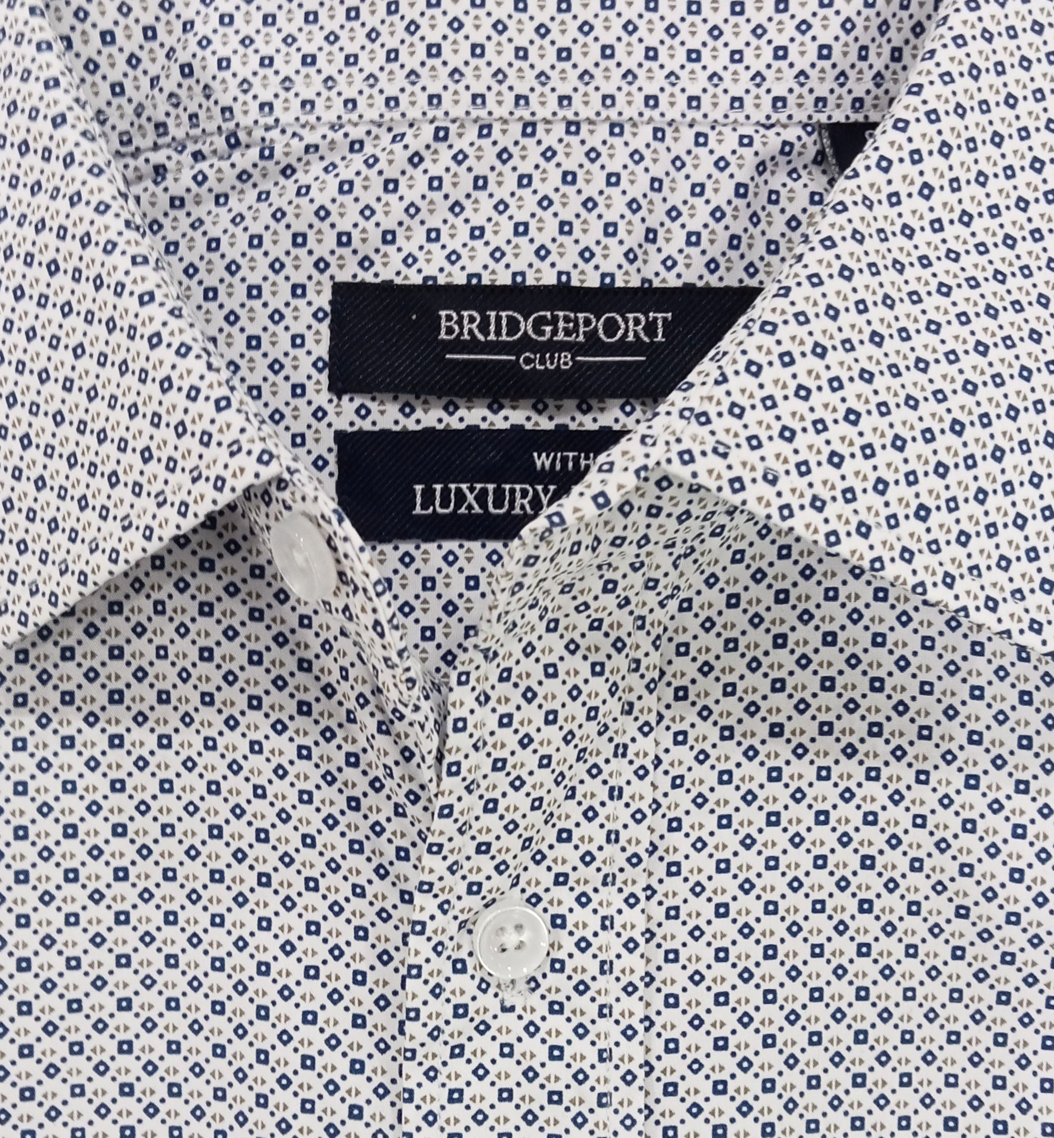 White dress shirt with blue geometric pattern and Bridgeport Club label on a white background