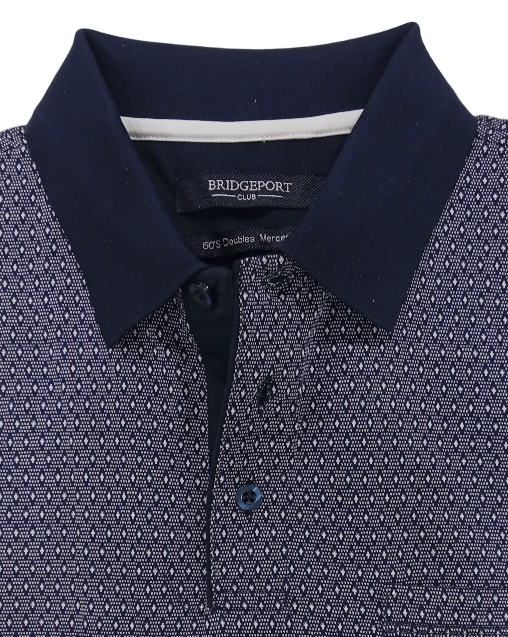 Folded navy polo shirt with white pattern on a light gray background