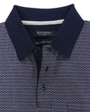 Folded navy polo shirt with white pattern on a light gray background