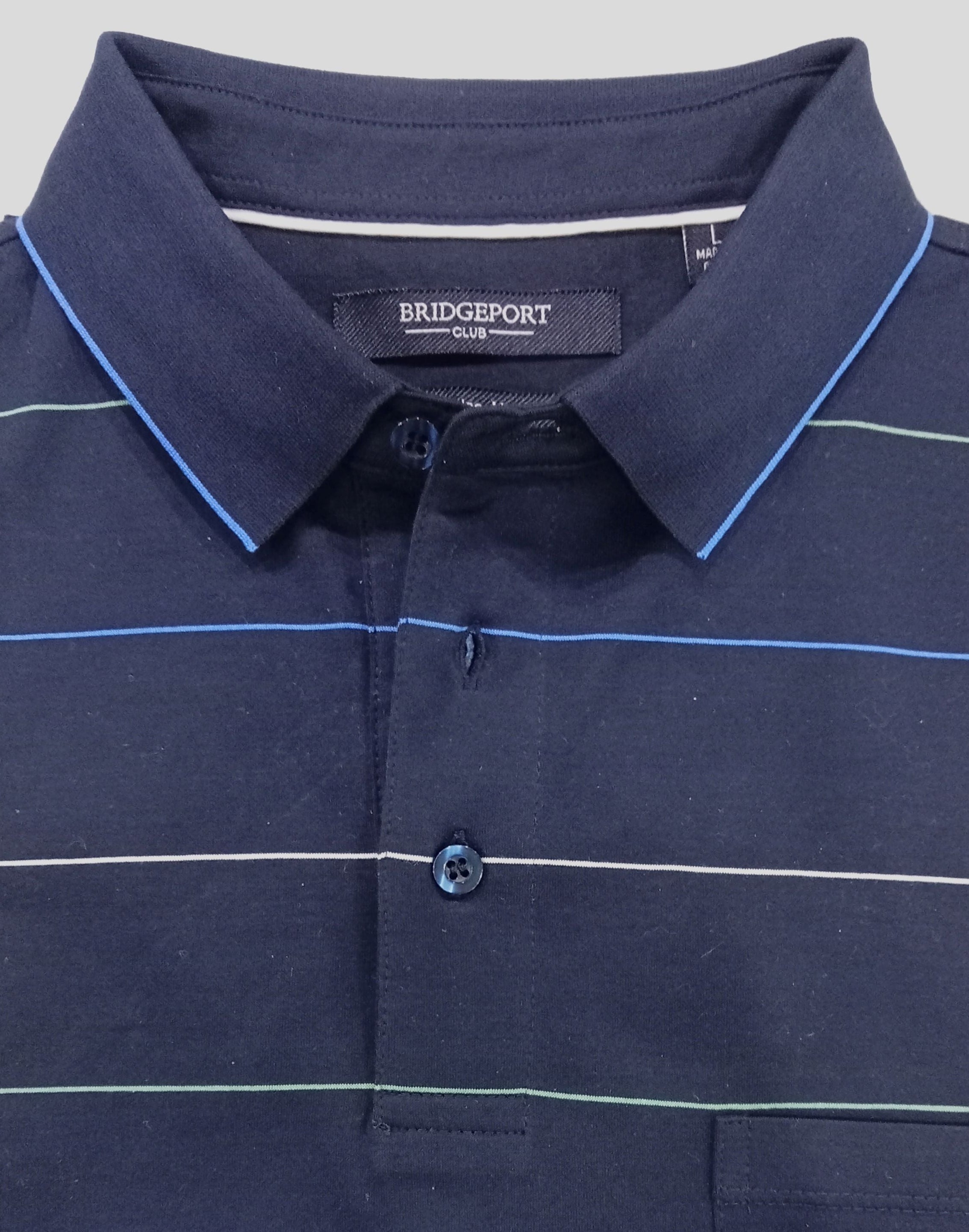 Folded navy polo shirt with white stripes on a gray background.