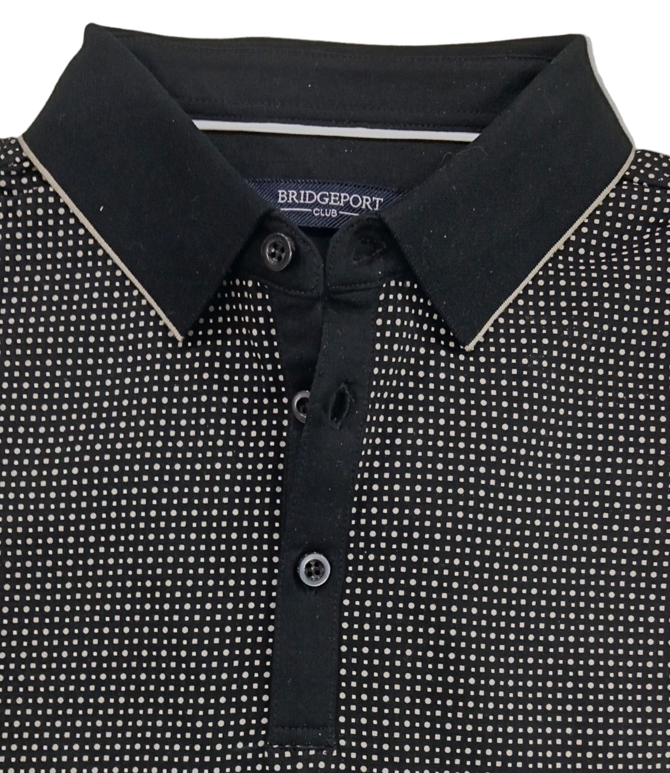 Folded black and white patterned polo shirt with 'Bridgestone' branding on a gray background