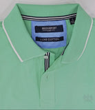 Green jacket with a blue patch on a white surface, person partially visible.