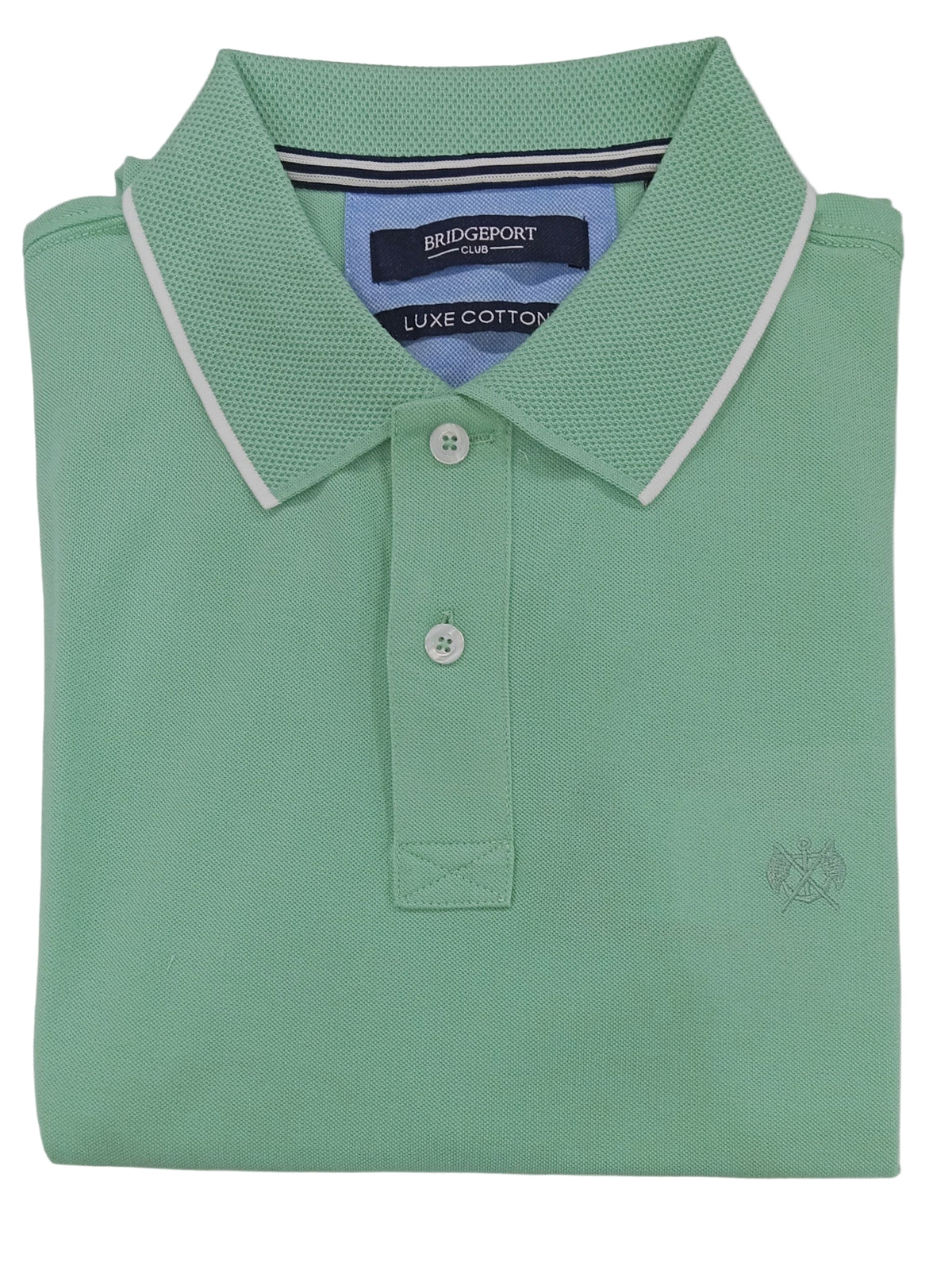 Folded green polo shirt on a light gray background