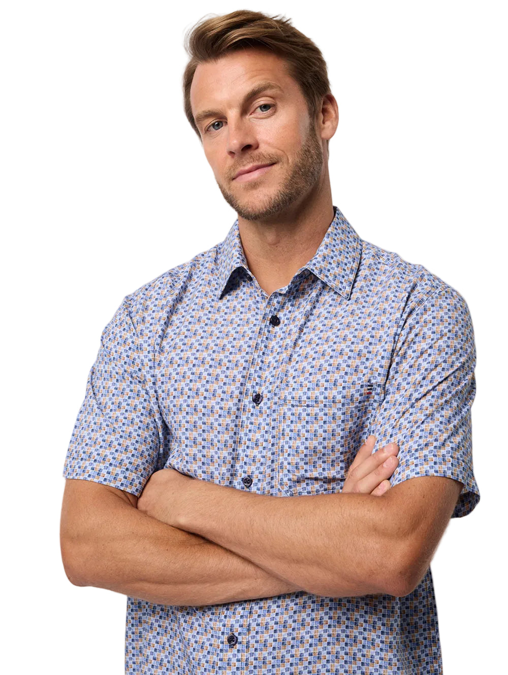 Man wearing a patterned shirt with arms crossed on a plain background