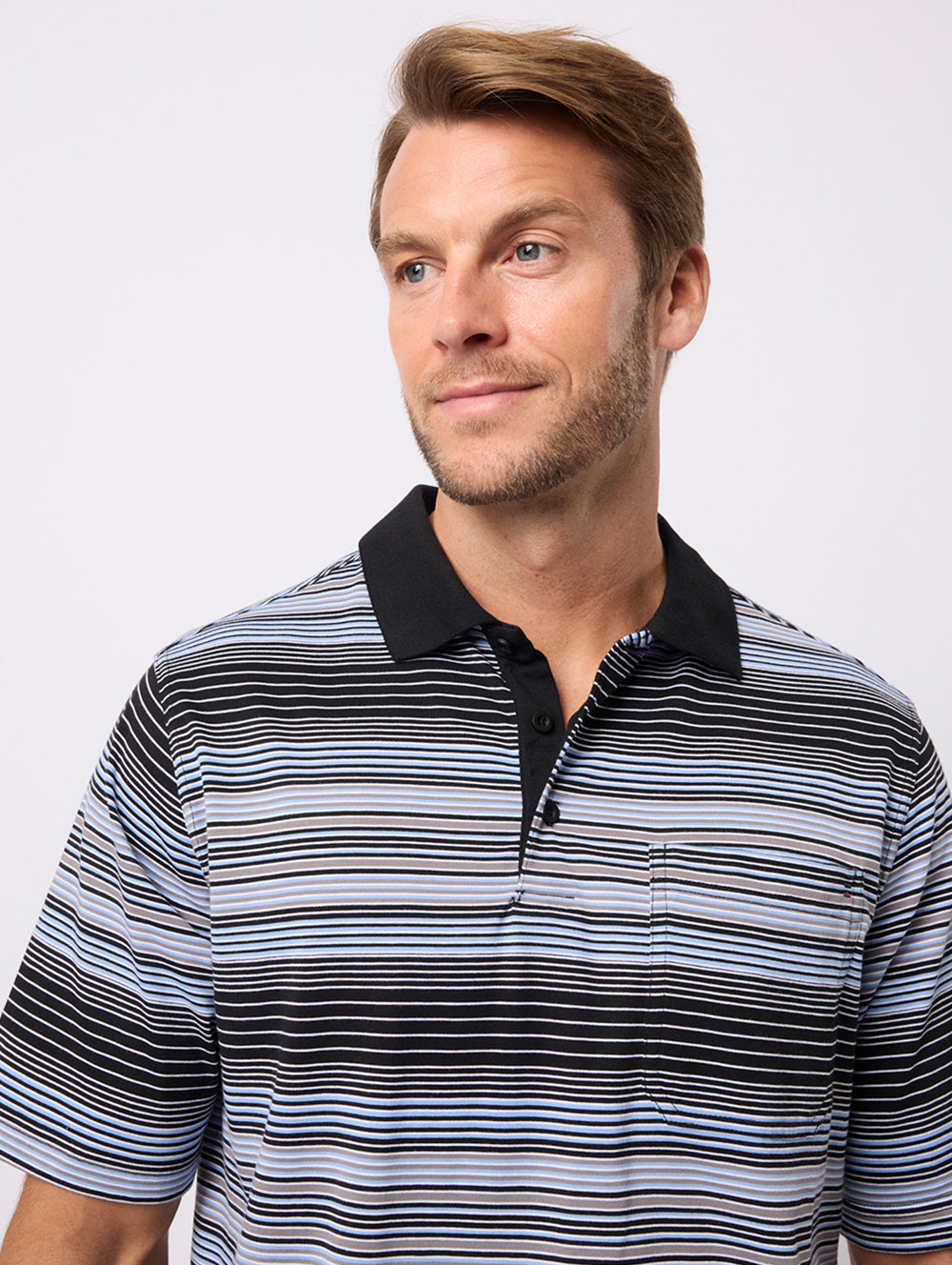Man wearing a striped polo shirt with a black collar on a white background
